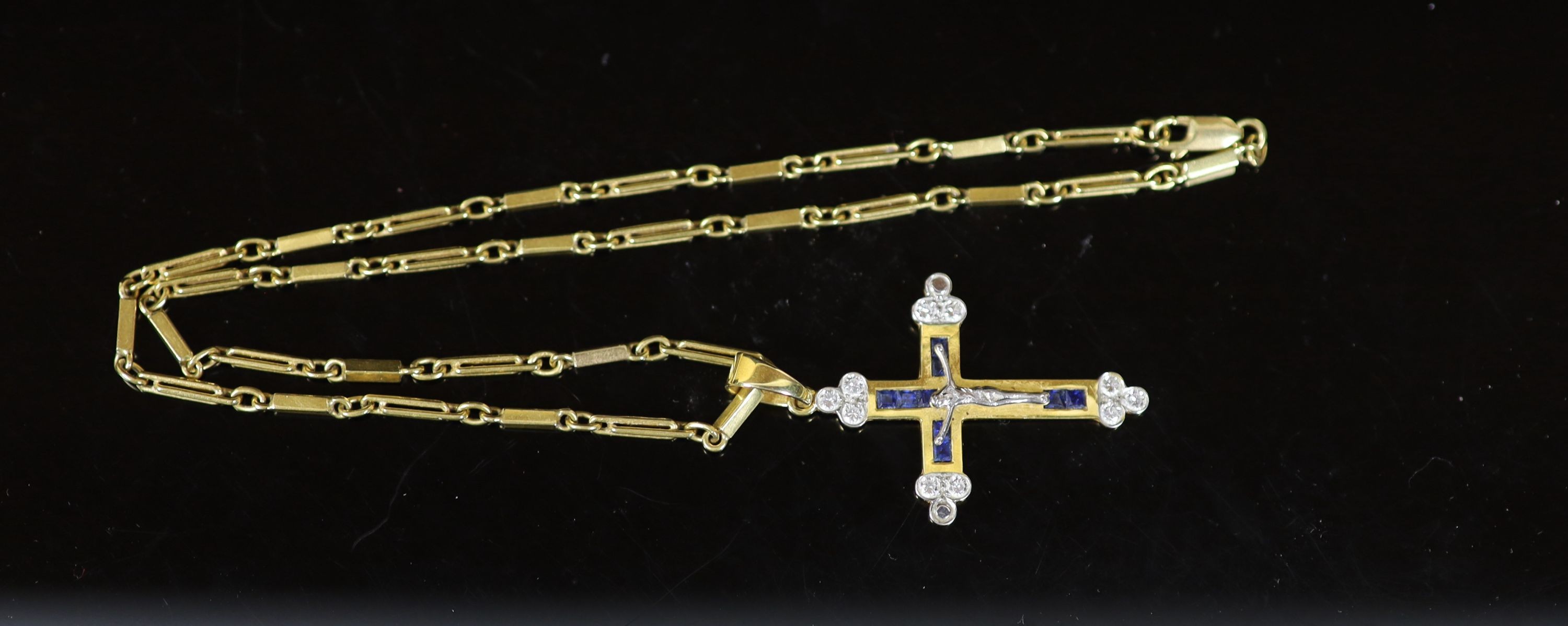 A modern 750 gold, sapphire and diamond set crucifix pendant, on a similar bar link chain